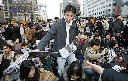 오마이뉴스 호외가 집회 참가자들 손으로 전달되고 있다. 